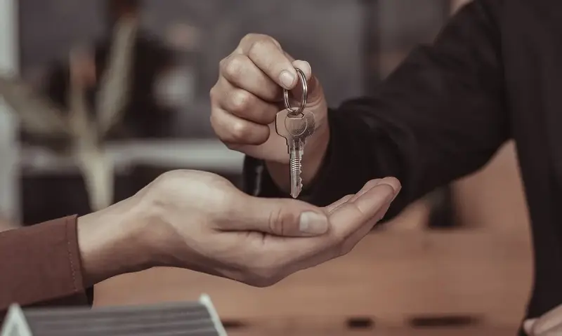 Real estate agent giving keys to new property owner